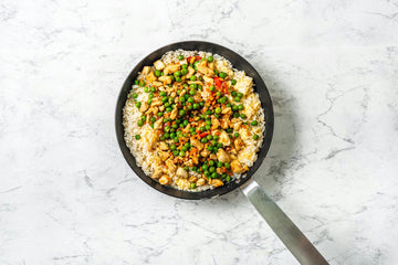 Pour the **rice** over the **half**-**cooked** **egg** and fry on a medium-high heat to get all the liquid. Add the **soy** **sauce** and **sesame** **oil** to the **fried** **rice** and pour in the **chicken**-**vegetable** **mixture**. Wait for the dish until Asian aromas start to come out of the pan.
