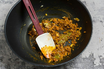 Heat **oil **in a pan. Fry the **onion **until glassy. Add **garlic, curry powder, turmeric** and **bay leaf** to the pan and heat once more.
