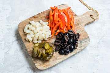 Clean and slice the peppers and halve the olives.
