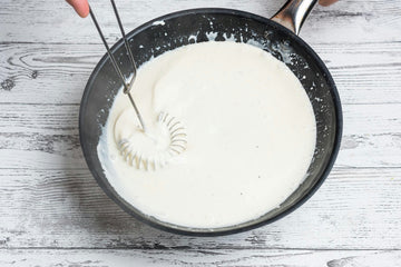 While the chicken is cooking in the oven, prepare the sauce on the stove. Mix **mustard**, **100 ml of water** and **chicken broth** in a pan over medium heat, let it boil and add the **cream cheese** while stirring constantly. Season with **sugar, salt** and **pepper**.
