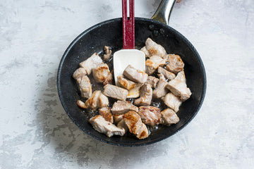 Heat olive oil in a pan and brown the pork pieces over high heat, then set aside. Add the chorizo, onion and garlic to the same pan and cook until the onion turns translucent.
