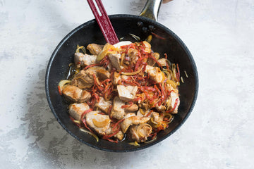 Then add the pork back to the pan and also add the paprika, pickled cucumber, olives, pearl onions and thyme.
