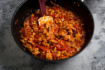Add **tomato paste, thyme, chicken broth, 200 ml of water** and **peeled tomatoes** to the **minced meat**, mix. Put the lid on and simmer on low heat for **30-40 minutes**. Add the **beans**, mix and heat for another **10 minutes** without the lid. Season with **salt, pepper** and **sugar**.
