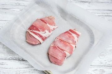Season the **chicken fillets** with **salt **and **pepper**. Wrap the **bacon **around each **chicken fillet** so that the ends of the bacon pieces are under the fillet. Place on a baking sheet. Bake in the oven for **35 minutes**. Increase the heat to **230 degrees** and cook for another** 5 minutes**.
