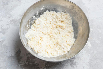 Heat the oven to **200 degrees**. Cut cold **butter **and add it with **baking powder** and** flour** to a bowl and mash between your fingers into a crumbly mass.
