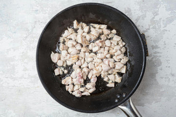Heat **oil **in a pan and fry the **chicken **for about **3 minutes**.
