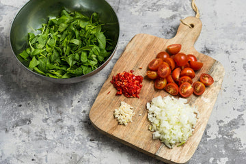 Peel and chop the **onion **and **garlic**. Chop the **chili pod** (spicy!) and halve the **cherry tomatoes**. Chop the **spinach** smaller. Cut the **green beans** into smalles pieces.
