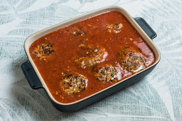 Bring the **sauce **to a boil and pour it over the **meatballs **in the baking dish.
